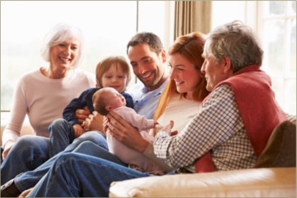 Picture of a multi-generational group, including a baby, sitting on a couch, communicating the need for dementia training to have healthy relationships.