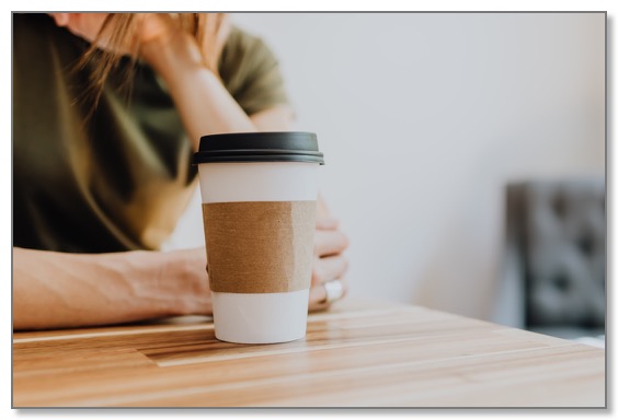 Picture of a hot take away drink on a table in front of a person needing relationships and support.