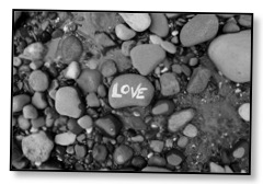 Picture of grey rocks and pebbles with love written on one to communicate love