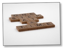 Picture of scrabble tiles displaying ‘one step at a time’ to communicate process