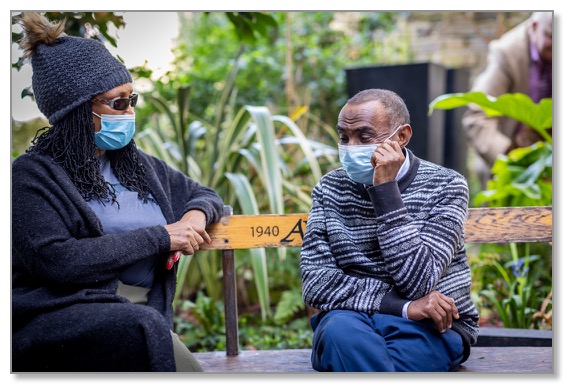 Picture of a woman sitting outside with a man, both wearing masks, demonstrating that with support healthy relationships are possible.