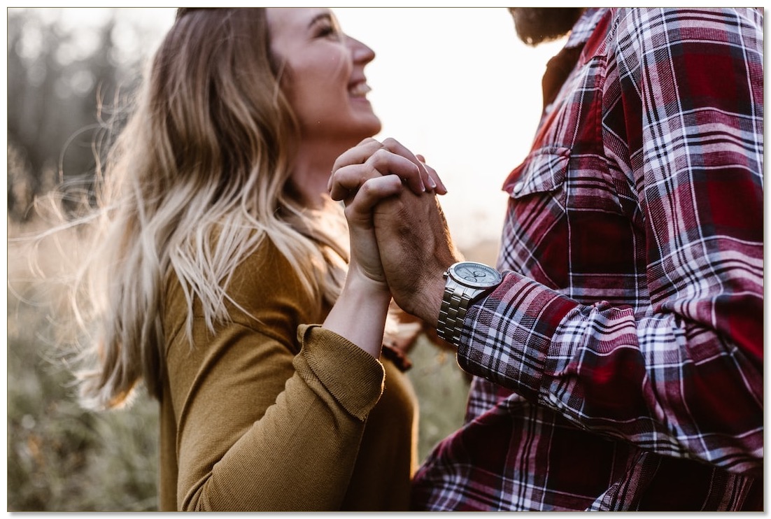 Picture of a woman and a man standing looking at each other, hands entwined, communicating the need for support to have healthy relationships.